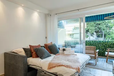 a bed in a room with a large window at Renovated apt with Parking & Terrace - Palm Beach in Cannes