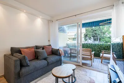 a living room with a couch and a table at Renovated apt with Parking & Terrace - Palm Beach in Cannes