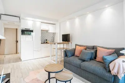 a living room with a couch and a table at Renovated apt with Parking & Terrace - Palm Beach in Cannes