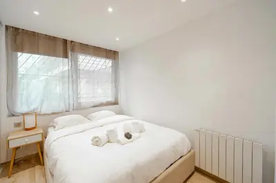 a white bedroom with a bed with towels on it at Renovated apt with Parking & Terrace - Palm Beach in Cannes