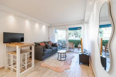 a living room with a couch and a table with a tv at Renovated apt with Parking & Terrace - Palm Beach in Cannes