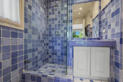 a blue tiled bathroom with a shower and a sink at REF 1849 - Cannes - Villa Provencal Style to rent in Le Cannet