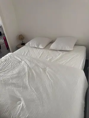 a white bed with two pillows on top of it at Appartement cosy in Cannes