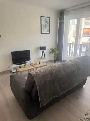 a living room with a couch and a tv at Appartement cosy in Cannes