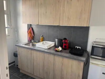 a kitchen counter with a sink and a microwave at Appartement cosy in Cannes