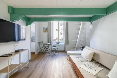 a living room with a couch and a green ceiling at LE PETIT PALAIS avec mezzanine de charme au cœur de Cannes in Cannes