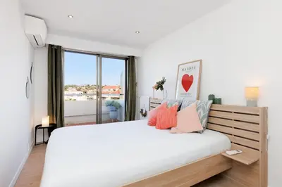 a bedroom with a large bed with a large window at Appartement lumineux Cannes proche mer in Cannes