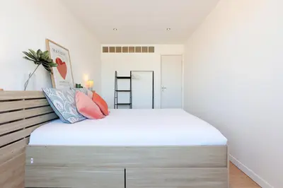 a bedroom with a large bed with white sheets at Appartement lumineux Cannes proche mer in Cannes