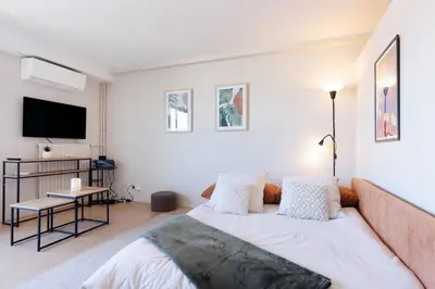 a bedroom with a bed and a flat screen tv at Appartement lumineux Cannes proche mer in Cannes