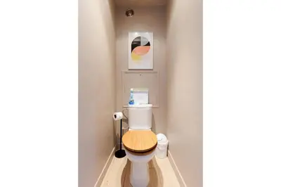 a small bathroom with a toilet with a wooden seat at Appartement lumineux Cannes proche mer in Cannes