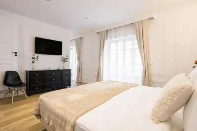 a white bedroom with a bed and a television at Gatsby Chic & Elegance & Billiards & Fitness & Luxury in Cannes