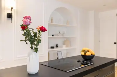 a white vase with flowers on a counter in a kitchen at Gatsby Chic & Elegance & Billiards & Fitness & Luxury in Cannes