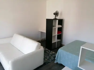 a living room with a white chair and a table at St Paul Cannes in Cannes