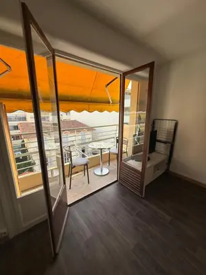 a room with a balcony with a table and a view at St Paul Cannes in Cannes