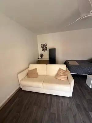 a living room with a white couch and wooden floors at St Paul Cannes in Cannes