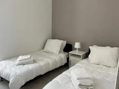 two beds in a room with white sheets and pillows at Villa carré des musiciens in Cannes