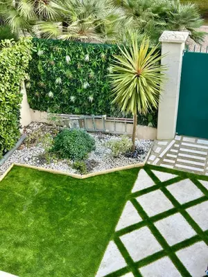 a garden with a small palm tree in the grass at Villa carré des musiciens in Cannes