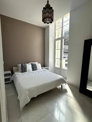 a white bedroom with a bed and a chandelier at Villa carré des musiciens in Cannes