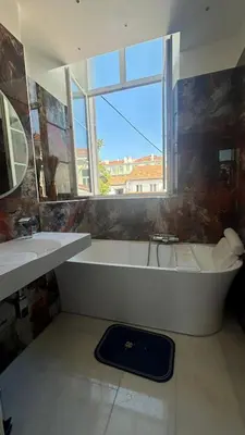 a bathroom with a tub and a sink and a window at Villa carré des musiciens in Cannes