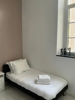a bed with two towels on it in a room at Villa carré des musiciens in Cannes