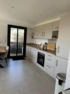 a kitchen with white cabinets and a table and a tableablish at Kazanou in Cannes