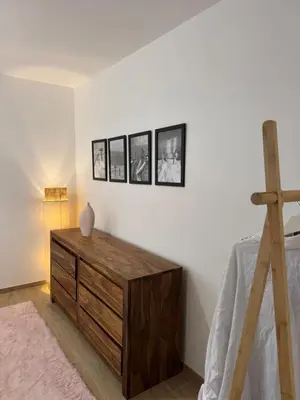 a room with a wooden dresser with four pictures on the wall at Kazanou in Cannes