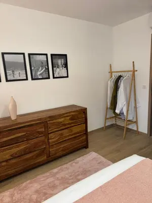 a bedroom with a wooden dresser and pictures on the wall at Kazanou in Cannes