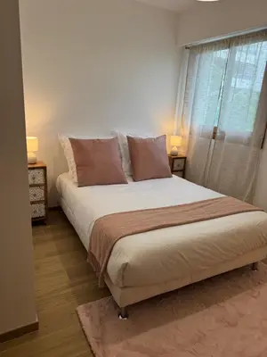a bed in a bedroom with two lamps and a window at Kazanou in Cannes