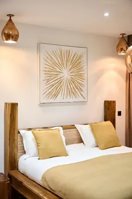 a bedroom with a wooden bed with white pillows at Alma Apart Residence in Cannes