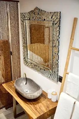 a bathroom with a stone sink on a wooden table at Alma Apart Residence in Cannes