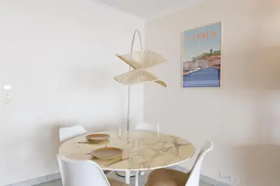 a white dining room with a table and chairs at Fettolina YourHostHelper in Cannes