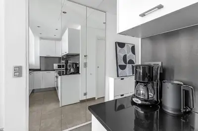 a kitchen with white cabinets and a blender on a counter at Croisette 65 apartment-Miramar residence in Cannes