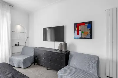 a living room with a chair and a dresser and a tv at Croisette 65 apartment-Miramar residence in Cannes