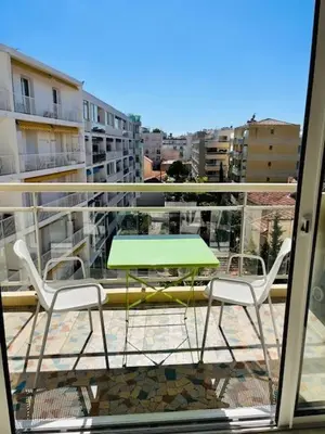 a green table and two chairs on a balcony at Cannes Palm Beach - Brand New Studio - Oasis of Calm in Cannes
