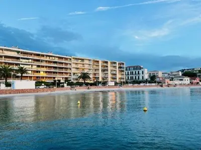a large body of water next to a beach with buildings at Cannes Palm Beach - Brand New Studio - Oasis of Calm in Cannes