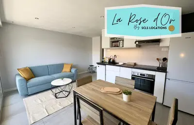 a kitchen and living room with a table and a blue couch at La Rose d'Or - SCLS Locations in Le Cannet
