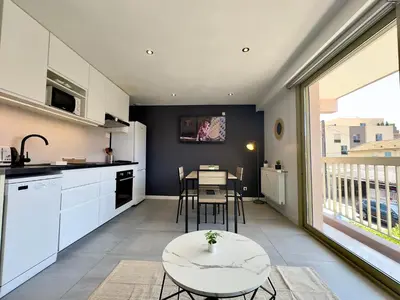 a kitchen with a table and a dining room at La Rose d'Or - SCLS Locations in Le Cannet