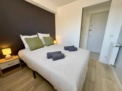 a bedroom with a large white bed with two pillows on it at La Rose d'Or - SCLS Locations in Le Cannet