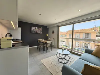 a kitchen and living room with a couch and a table at La Rose d'Or - SCLS Locations in Le Cannet