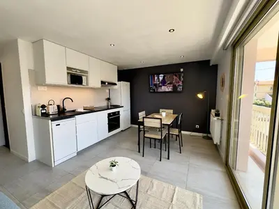 a kitchen and dining room with a table and a table at La Rose d'Or - SCLS Locations in Le Cannet