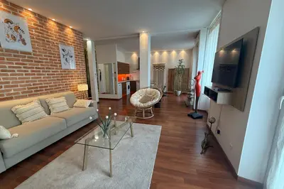 a living room with a couch and a brick wall at REF 1988 -Charming apartment in the center of Cannes in Cannes