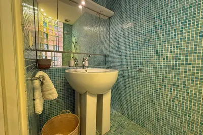 a bathroom with a sink and blue tiled walls at REF 1988 -Charming apartment in the center of Cannes in Cannes