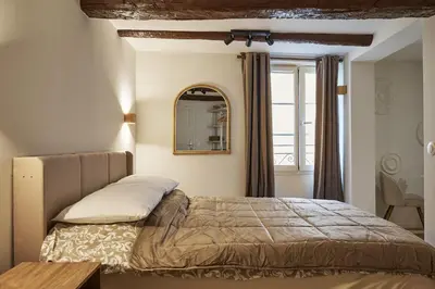 a bedroom with a bed and a mirror on the wall at Old Town Apartments By Villa Botanica in Cannes