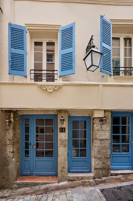 a building with blue doors and windows at Old Town Apartments By Villa Botanica in Cannes