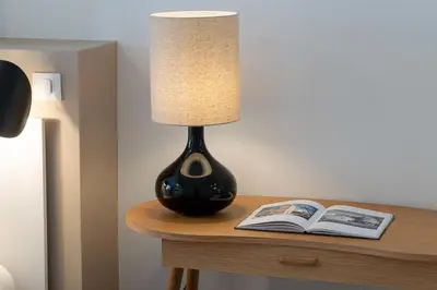a lamp sitting on a table next to a book at 2-Br Apartment Terrace Cannes City Centre in Cannes