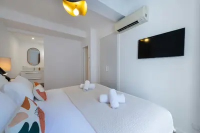 a white bedroom with a large white bed with white pillows at 2-Br Apartment Terrace Cannes City Centre in Cannes