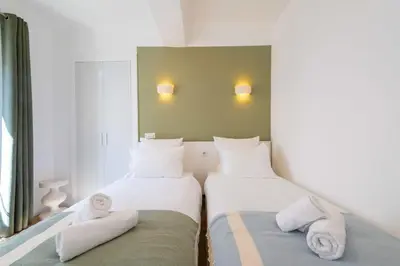 two beds in a small room with towels at 2-Br Apartment Terrace Cannes City Centre in Cannes