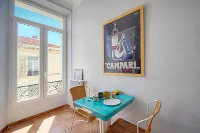 a table and chairs in a room with a window at Lumineux 2 chambres, CARRE D'OR-COEUR DE CANNES A2B196 in Cannes