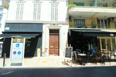 a restaurant with tables and chairs in front of a building at Lumineux 2 chambres, CARRE D'OR-COEUR DE CANNES A2B196 in Cannes