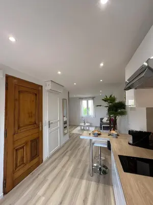 an open kitchen and living room with a wooden door at Studio Vue Mer au coeur du Suquet in Cannes